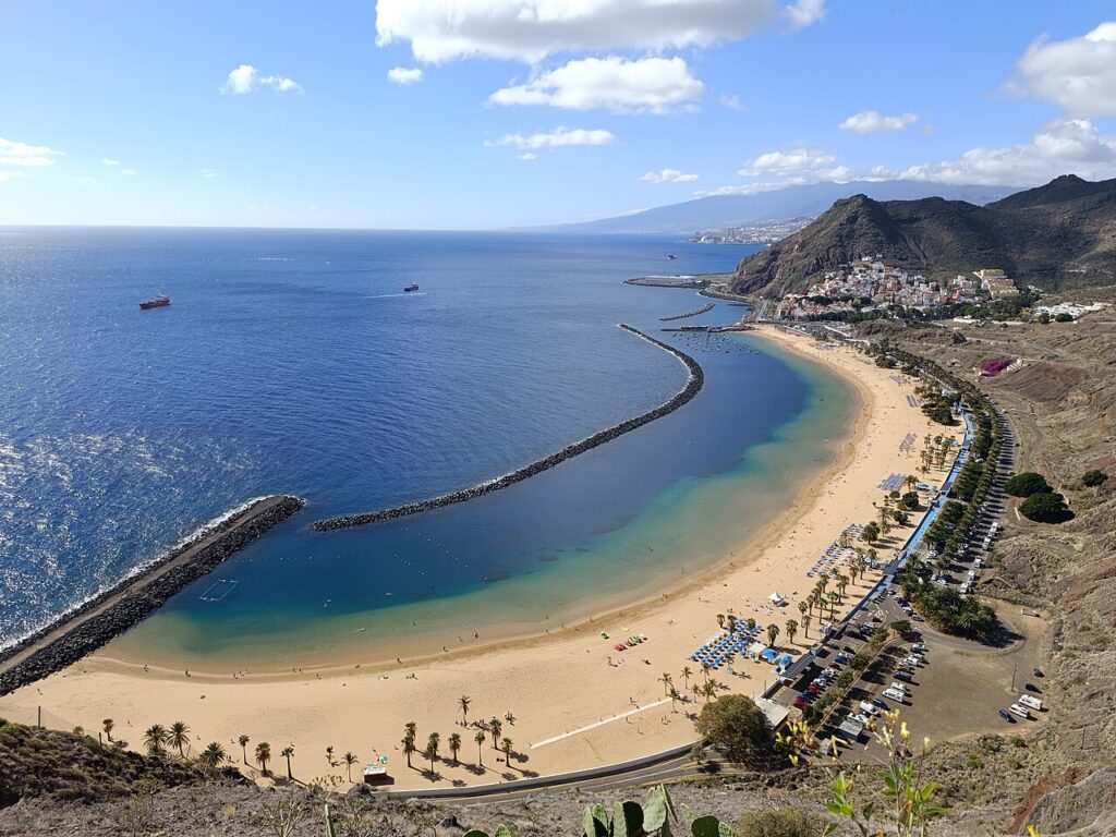 Plaża Las Teresitas z jasnym piaskiem i palmami pod górami Anaga, widok z punktu widokowego przy drodze do Igueste de San Andrés